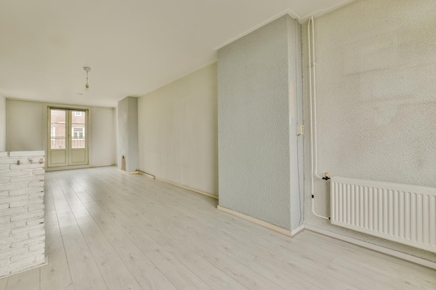 L'intérieur d'une chambre spacieuse avec une grande porte à l'extérieur et du parquet