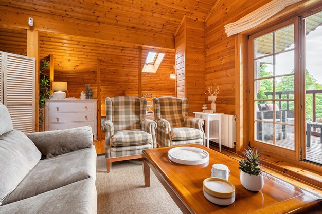 Photo intérieur confortable d'une maison de campagne dans un salon de design en bois avec terrasse et vue sur la forêt