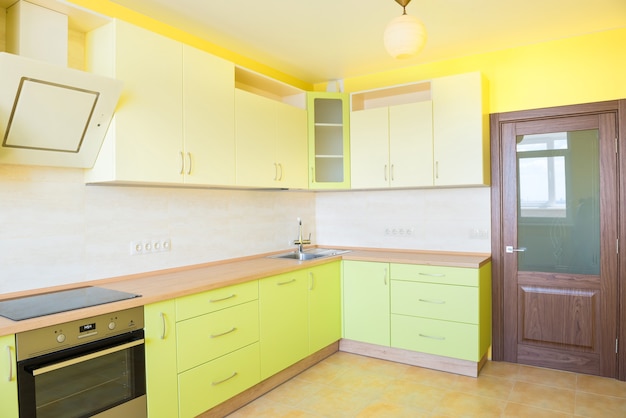 Intérieur de cuisine dans un appartement moderne. Chambre ensoleillée vide jaune clair