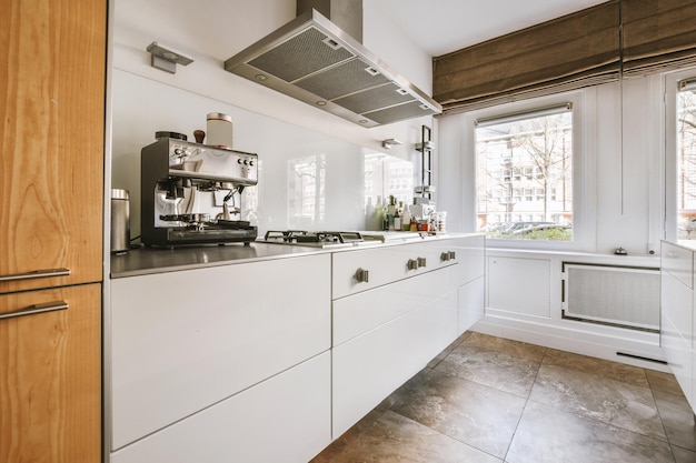 L'intérieur de la cuisine dans un style minimaliste dans des tons blancs avec un sol en marbre