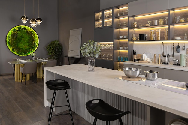 intérieur de cuisine de luxe élégant dans un appartement spacieux ultra-moderne aux couleurs sombres avec un éclairage led super cool et un îlot pour cuisiner et une table à manger