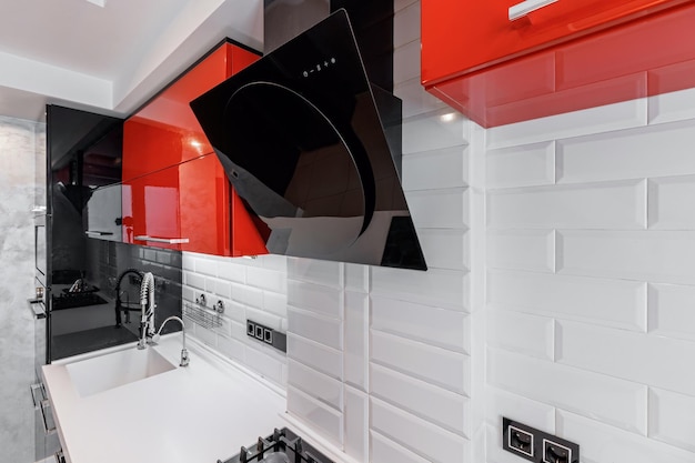 Intérieur de cuisine moderne avec armoires rouges et noires et sol en céramique blanche