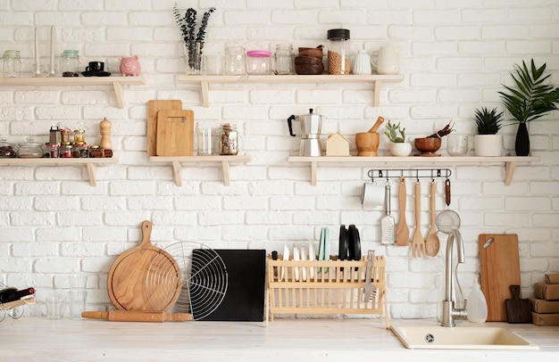 Intérieur de cuisine rustique avec mur de briques blanches et étagères en bois blanc