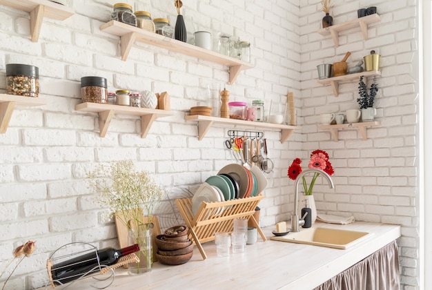 Intérieur de cuisine rustique avec mur de briques blanches et étagères en bois blanches