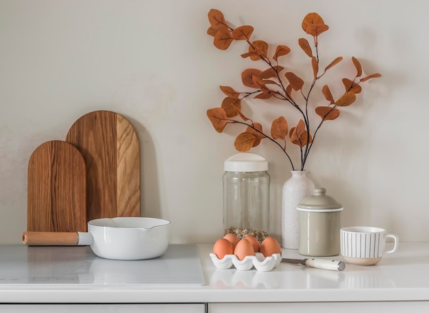 Intérieur de cuisine de style scandinave minimaliste Casserole planches à découper œufs décor d'automne sur meubles de cuisine blancs dans une cuisine lumineuse