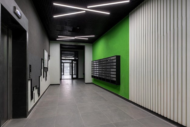 Intérieur du hall du couloir, avec porte d'entrée et ascenseur dans de nombreux immeubles d'appartements, avec boîtes aux lettres aux murs verts