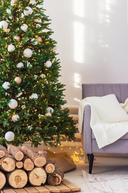 Intérieur du Nouvel An ou de Noël dans le salon. Canapé, plaid, sapin de Noël décoré