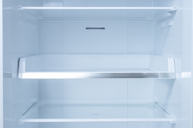 Photo à l'intérieur du réfrigérateur propre et vide avec des étagères.