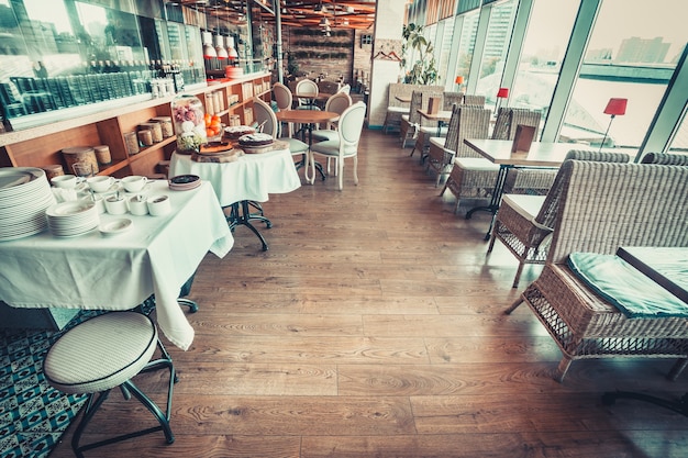 Intérieur du restaurant moderne avec tables, chaises et vaisselle