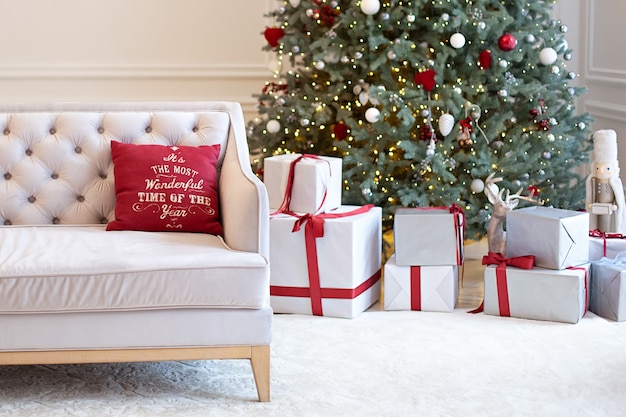 intérieur du salon avec canapé décoré de sapin de Noël, cadeaux et oreillers. Noël à la maison.