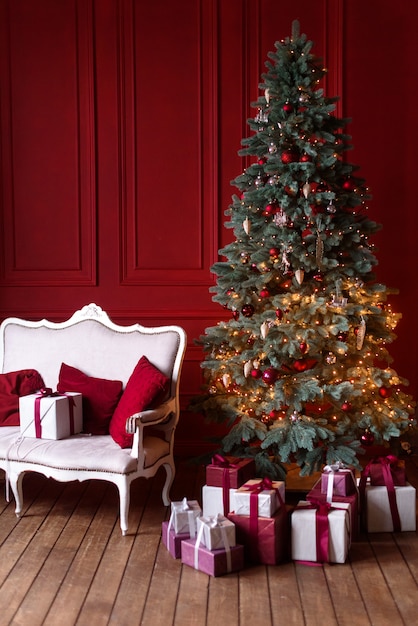 L'intérieur du salon dans le style de Noël avec un grand sapin et des cadeaux de Noël