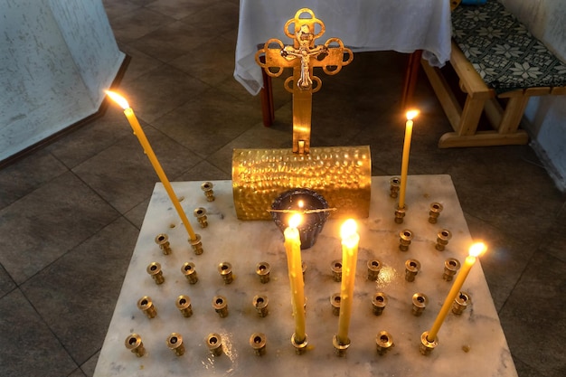 L'intérieur de l'église Bougies allumées et icônes de saints à l'intérieur du temple