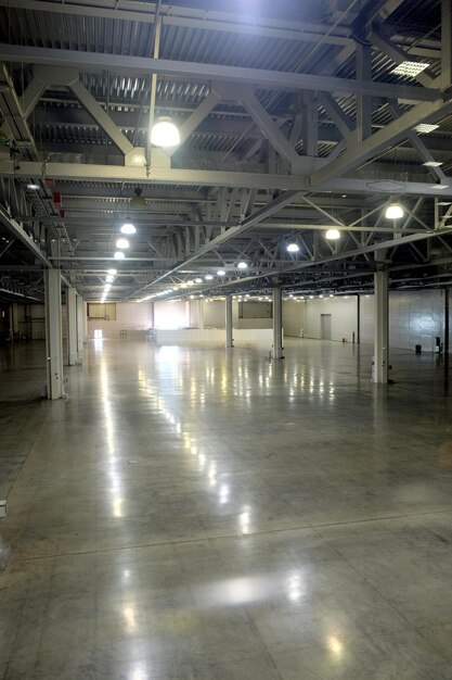 Photo l'intérieur d'un entrepôt vide dans un bâtiment industriel avec de hautes colonnes verticales et un plafond élevé