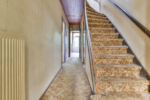 Intérieur d'un escalier élégant dans un couloir recouvert de moquette marron blanc