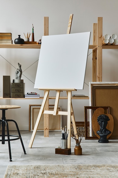 Photo intérieur d'espace de travail d'artiste unique avec chevalet en bois, bibliothèque, œuvres d'art, accessoires de peinture, décoration et objets personnels élégants. salle de travail moderne pour artiste. modèle.