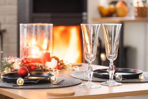 L'intérieur festif de la maison est décoré pour Noël et le Nouvel An dans un style loft avec un poêle à bois noir, un sapin de Noël, un studio chaleureux avec table à bois, confortable et chauffage de la maison