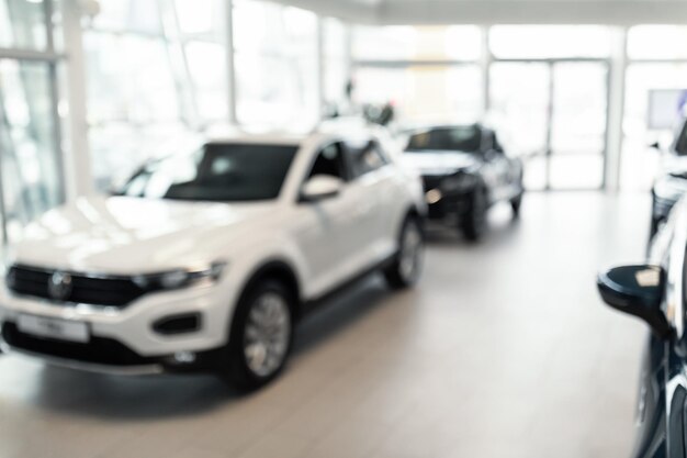 Intérieur flou du magasin du concessionnaire automobile avec de nouvelles voitures de luxe, achat de véhicules dans l'espace vide