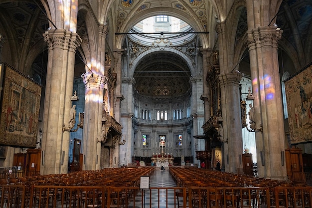 L'intérieur d'une grande église avec de nombreux bancs et un haut plafond