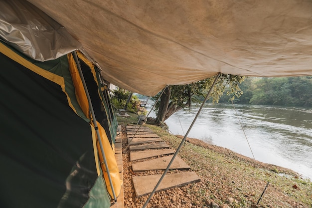 À l'intérieur d'une grande tente de camping confortable sur un terrain de camping dans la forêt tropicale au bord de la rivière en vacances