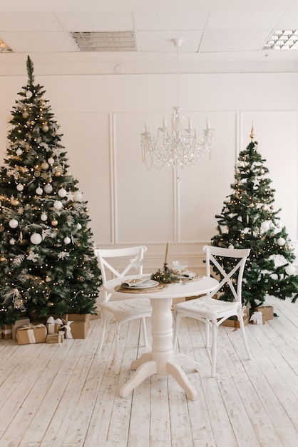 Intérieur lumineux et élégant du salon avec un sapin de Noël et une table de fête