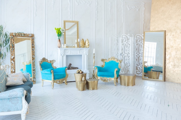 Intérieur lumineux de luxe du salon avec mur d'or et meubles chics chics aux couleurs blanc et or