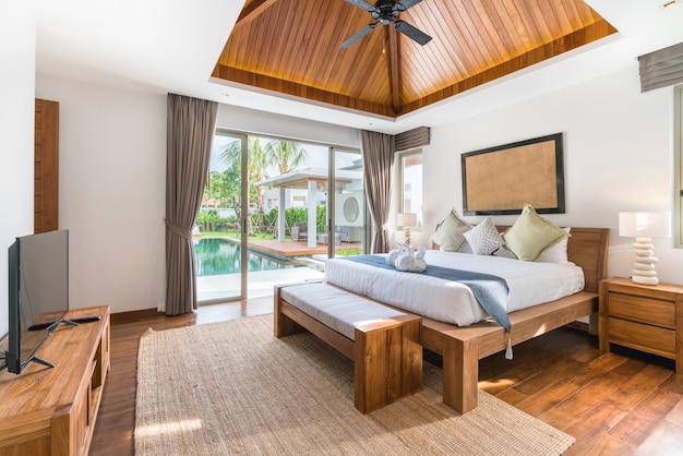 Intérieur de luxe dans la chambre de la villa avec piscine et lit king confortable.