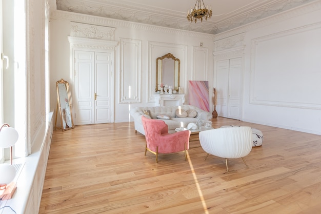 Photo intérieur de luxe de style baroque très léger du grand salon. murs blancs décorés de stuc impressionnant. appartement de style royal avec des meubles chics avec des éléments dorés