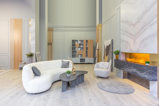 Intérieur luxueux et élégant d'un studio moderne aux couleurs pastel vertes avec des éléments en bois, des meubles et des décorations coûteux, un coin salon confortable à côté de la cheminée