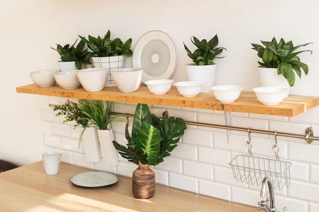 Intérieur à la maison d'une cuisine scandinave lumineuse élégante à la mode avec l'intérieur de grenier d'étagères ouvertes