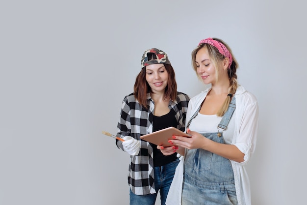 Intérieur de maison deux jolies filles designer et peintre font des réparations dans la maison une équipe de décorateurs