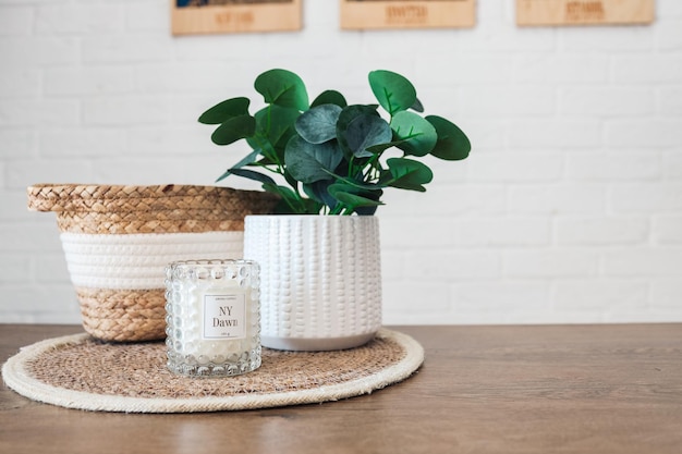 Intérieur de la maison Nature morte avec des détails Panier en osier avec des plantes et des bougies sur la table de la cuisine le concept de confort Close up