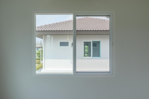 Intérieur de maison à ossature de fenêtre en verre sur mur blanc