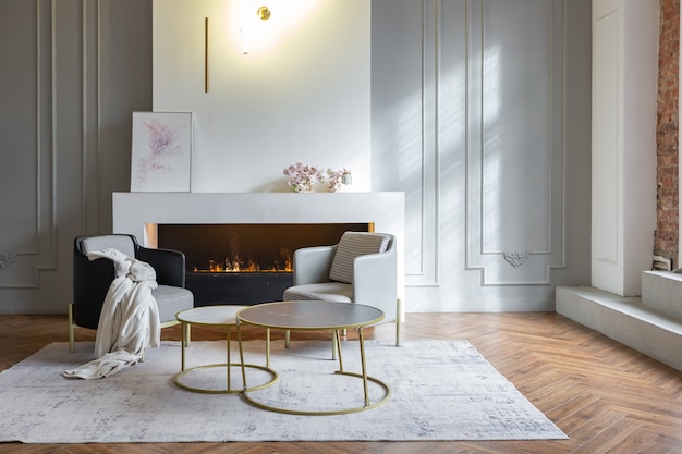 Intérieur minimaliste d'un appartement décloisonné ultra moderne avec des murs blancs et gris avec des meubles rembourrés élégants en relief et gris et d'immenses fenêtres