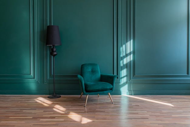 Intérieur minimaliste de la salle de séjour dans un style classique avec fond. Mur en plâtre vert orné de moulures, canapé et lampadaire sur parquet.
