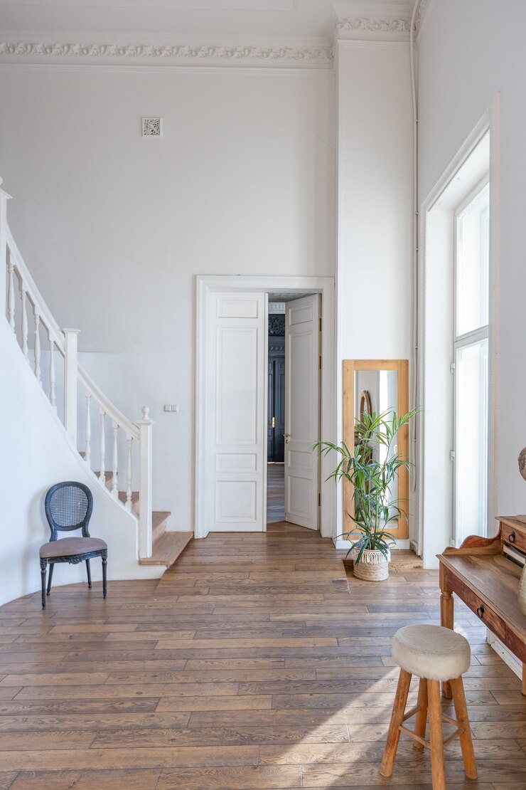 Photo intérieur moderne d'une chambre lumineuse dans un appartement de deux étages avec des objets de décoration de style balinais avec balcon. murs blancs, parquets et meubles vintage