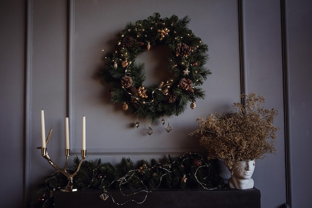 Intérieur moderne du salon Cheminée contemporaine de sapin de Noël créatif et grand fauteuil gris dans un appartement de design d'intérieur loft Concept de fond de vacances Joyeux Noël Nouvel An