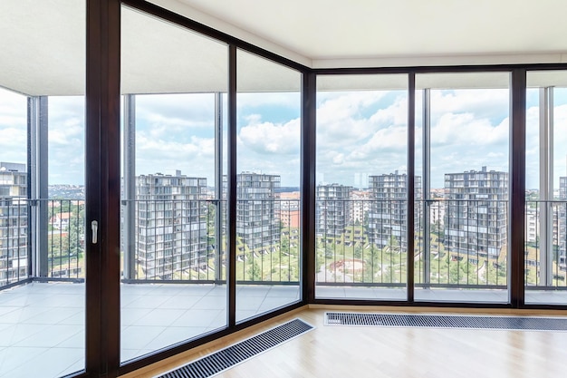 Intérieur moderne d'un loft vide blanc avec parquet et fenêtres panoramiques donnant sur la métropole