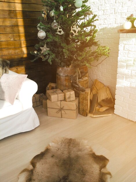 Intérieur moderne et lumineux et confortable du salon avec canapé confortable, bois de cheminée, noël