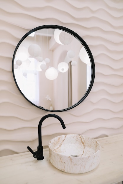 Intérieur moderne avec miroir rond élégant par mur beige dans une chambre confortable copie espace accessoires élégants dans un décor élégant