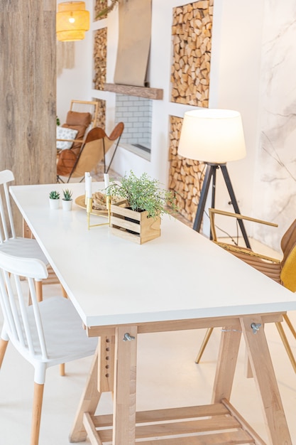 Intérieur Moderne à La Mode D'un Studio Lumineux Avec Des Colonnes En Bois De Style Loft, Décoré De Briques, De Marbre Et De Bois Avec Des Meubles élégants Et Des Murs Blancs