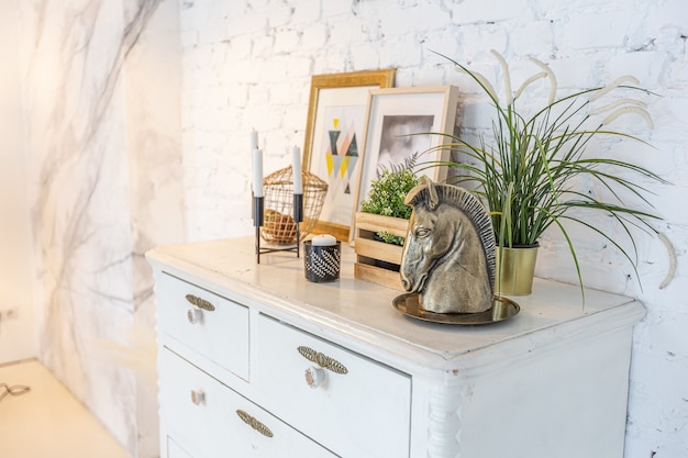 Intérieur moderne à la mode d'un studio lumineux avec des colonnes en bois de style loft, décoré de briques, de marbre et de bois avec des meubles élégants et des murs blancs