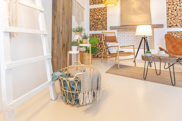 Intérieur moderne à la mode d'un studio lumineux avec des colonnes en bois de style loft, décoré de briques, de marbre et de bois avec des meubles élégants et des murs blancs