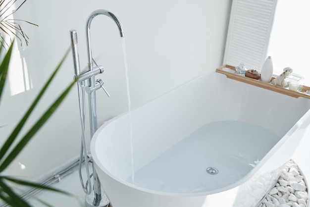 Intérieur moderne de salle de bains blanche Décor luxueux avec spa de fenêtre de plantes à la maison La baignoire est remplie d'eau du robinet personne