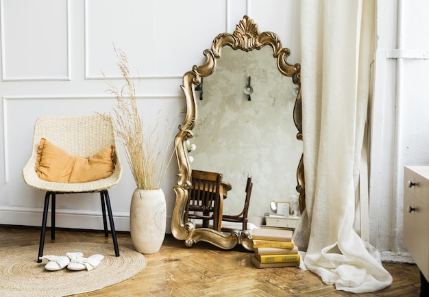 Intérieur moderne de style boho Grande chaise en osier miroir en forme et tapis dans la chambre