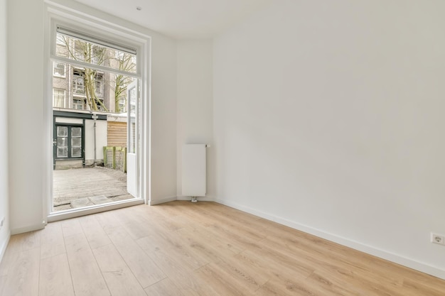 L'intérieur d'une petite pièce en blanc avec parquet et accès à la rue par la porte