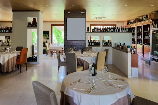 Intérieur de restaurant rétro avec étagères à vin et tables avec chaises et verres sur fond. Décoration de bar Italien Vintage. Personne à l'intérieur. Décor du bar de l'hôtel pour les fêtes en Italie.