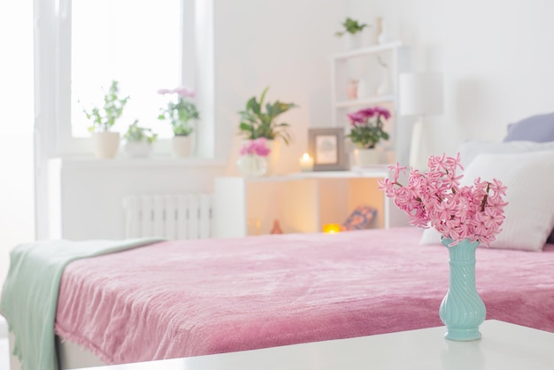 Intérieur rose et blanc de la chambre avec des fleurs printanières