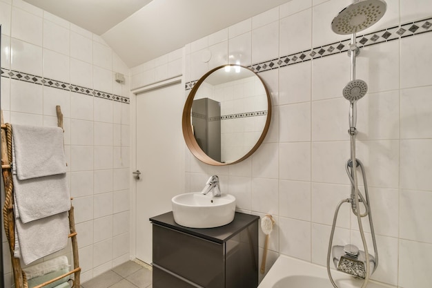 Intérieur de la salle de bain avec carrelage blanc et motif dessus ainsi qu'avec un lavabo en céramique et une baignoire