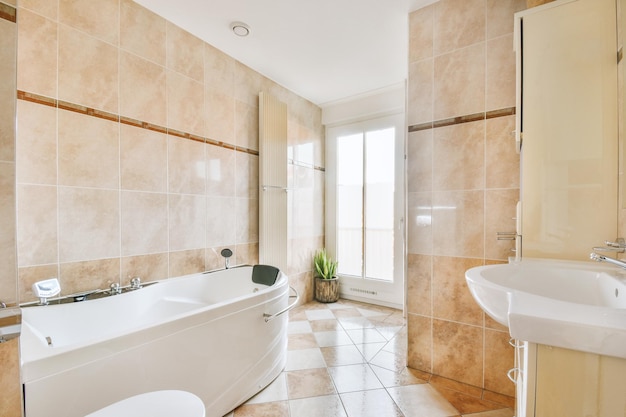 Intérieur de la salle de bain fini avec des carreaux de marbre avec baignoire et lavabo dans une maison moderne