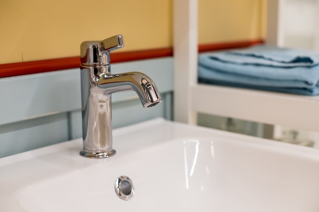 Intérieur de la salle de bain avec lavabo et robinet blanc